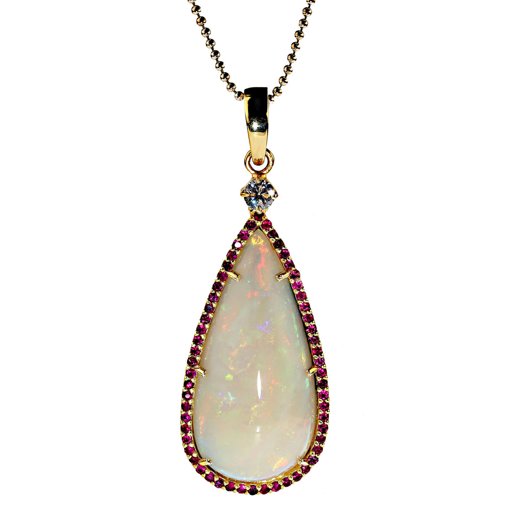 Pendant of magnificent teardrop Opal flashing red and green surrounded by rubies